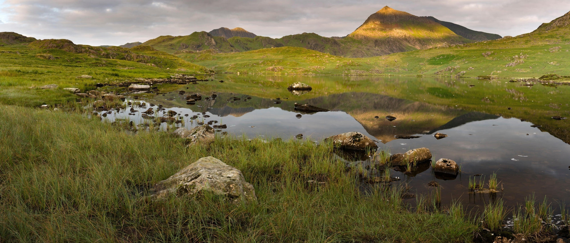  Sunlight shines on Crib Goch as it reflects in Llyn Cwmffynnon, Snowdonia. Image via Alamy