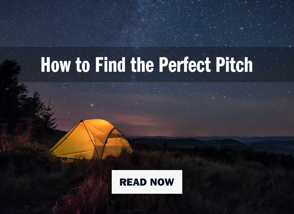 yellow tent lit up at night under a starry sky